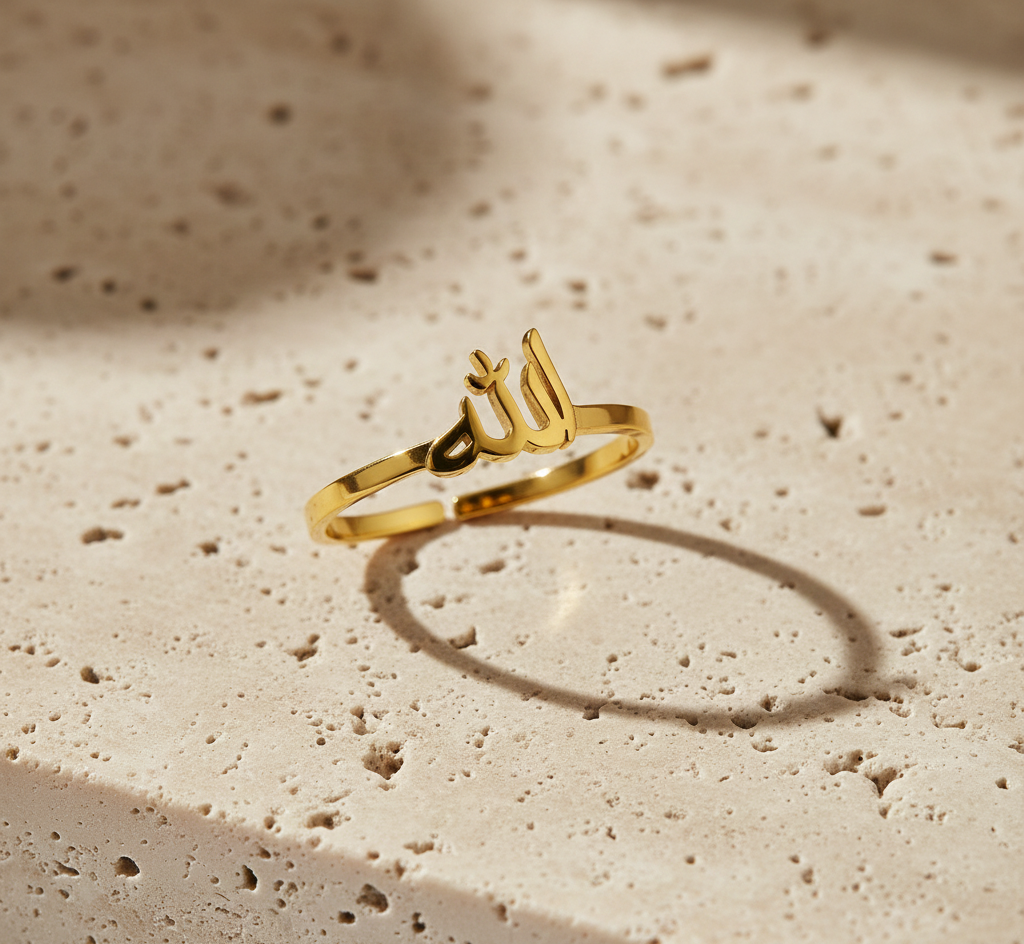 Gold ring with Arabic calligraphy on a textured beige surface